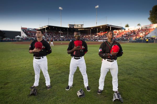The Vancouver Canadians outfielders (left-right) Chris Carlson, Roemon Fields, and Jonathan Davis during the national anthems before the start of a home game at Nat Bailey Stadium vs. the Spokane Indians.