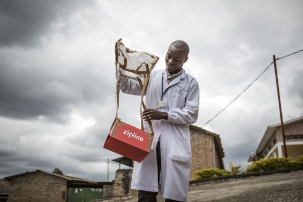 Kabgayi hospital lab technician Prosper Uzabariho collects a package containing blood dropped by paper parachute from the Zipline drone to the hospital.