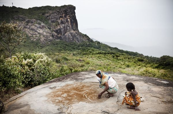 A mother and daughter lay cous out to dry on the rocks in the Fouta Djallon highlands of Guinea - source of the Niger, Senegal and Gambia river.