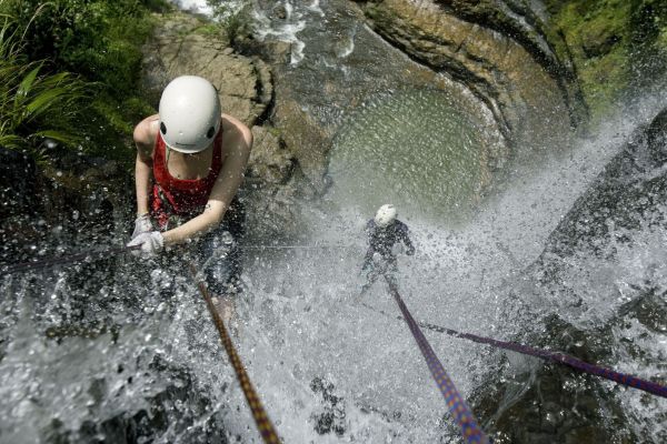 A french tourist descends rappel style the water falls of Fonce river in Santander, Colombia, June 6, 2008.