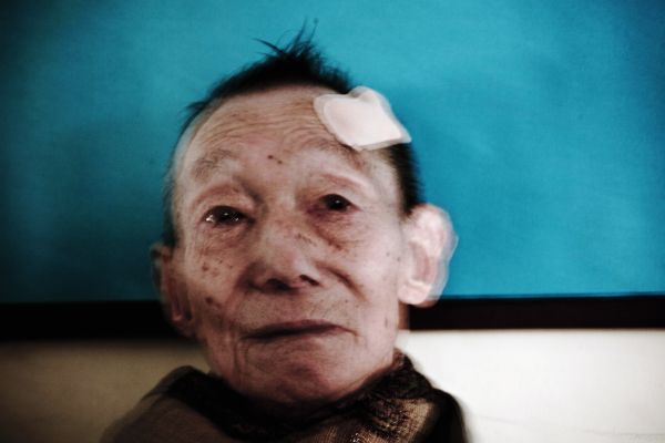 A survivor looks into the air at an evacuation camp in a elementary school in Onagawa, as more than half of the district population have been missing due to the monster tsunami. Onagawa, Miyagi, March 16, 2011.