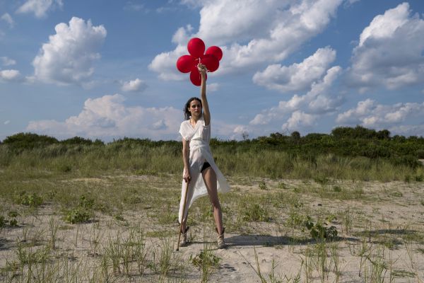 Rebecca, who nearly always needs a cane due to brain trauma injury and the permanent paralysis, though low level, poses with red baloons.