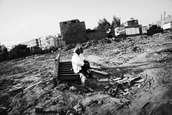 Two Uighur men are staying at their demolished and flattened community due to the Chinese modernization projects or Chinesefication, though the government insists the main reason is security of houses -- especially resistance to earthquake, in Kashgar, Xinjiang.