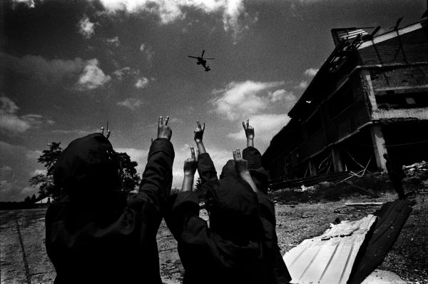 Kids in Kosovo flush the victory signs at an American copter after the liberation, 1999.