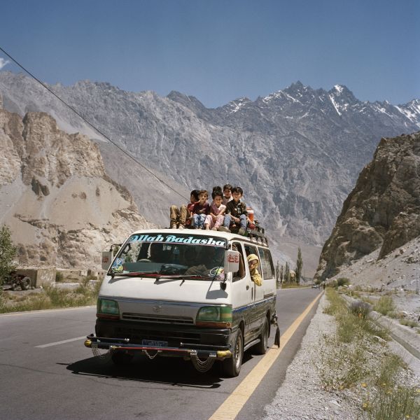 Local children pack onto the roof of a van to travel through the Hunza Valley in Pakistan on July 15, 2018.