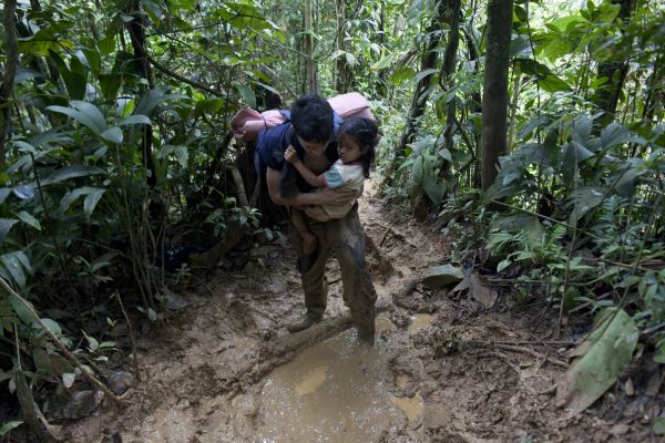 Jose Lopez, 30, carrying his daughter, Joseyli, 4, during a climb through The mountain of death, as this portion of the Darien is known. Darien gap jungle, Panama, October 27, 2021.