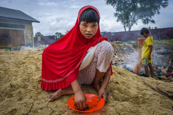 Alakama, 10, washes chili, as a part of pretend cooking, at a refugee site converted from an unused government complex in Lhokseumawe, northern Aceh Province of Indonesia.