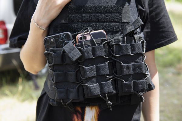 Tetyana Ivleva, deputy head of Tsyrkuny, a village located just north of Kharkiv, keeps two mobile phones tucked into her body armor while humanitarian aid is delivered during shelling of the village by Russian forces.