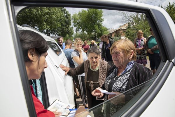 Lyubov Terikh (at right) speaks with a humanitarian aid worker from Proliska while she and other villagers wait for humanitarian aid in Biskvitne, a village located approximately 7km east of Kharkiv.