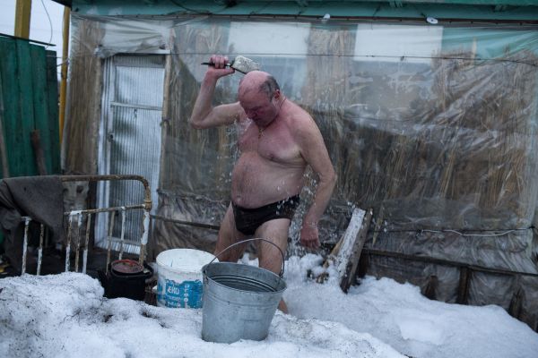 Anatolij Malenik, a retired 69 year-old metallurgical engineer from Luhansk, a separatist held city, baths outside of his tiny summer house that he insulated using straw for winter use in Stanytsia Luhanska in Ukrainian controlled territory near the line of control.