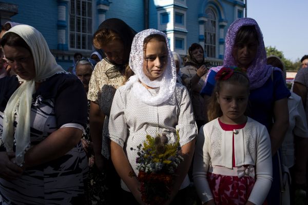 Villagers who support the Ukrainian Orthodox Church Kiev Patriarch celebrate Spas, a Christian holiday, outside of the Church of the Holy Dormition in the village of Ptycha.
