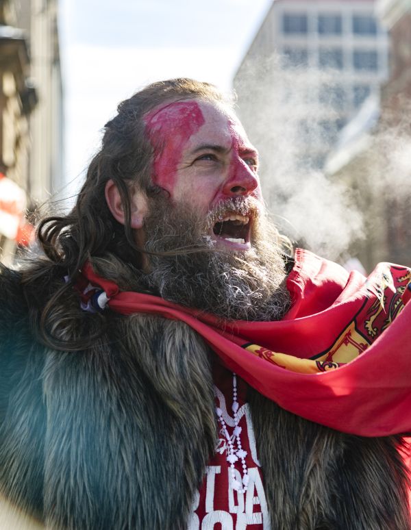 A man with face-paint mimicking the Canadian flag shouts the word “freedom” on Wellington street across from the Canadian Parliament.