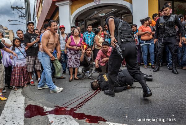 Officer Carlos Juracan, a member of the police anti-narcotics squad lies dying after intercepting a criminal on a pedestrian mall in the centre of Guatemala City.