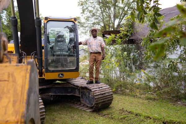 Bulldozer operator Jimmy Johnson demolishes a home in Drew, Mississippi.