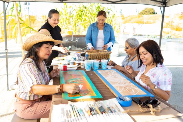 Paradise Creek Community Garden members (managed by Mundo Gardens) painting signs at the garden in National City, California.
