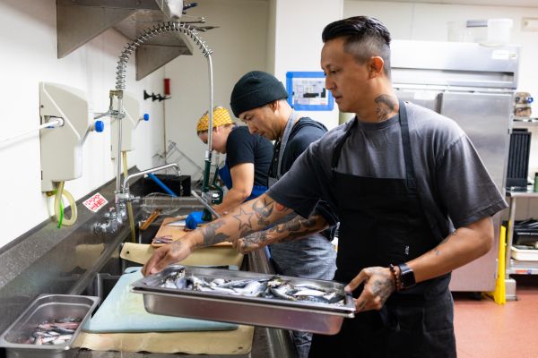 Chef Phillip Esteban, Marcus Twilegar and Sydney Imlay prepare sardines at his restaurant Parq SD in San Diego, California.