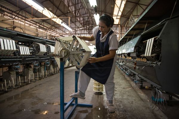An employee of the Jim Thompson Silk Company works inside the mechanised spinning room at the Jim Thompson silk factory in Nakhon Ratchasima Province.