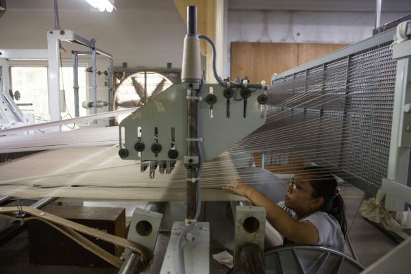 An employee checks a weaving machine inside the mechanised machine weaving room of the Jim Thompson factory located in the town of Pak Thong Chai in Nakhon Ratchasima Province.