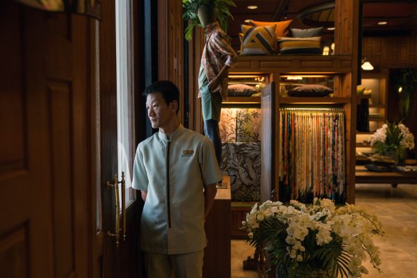 Shot for Bloomberg doorman waits to open the door to customers at the Jim Thompson flagship store in central Bangkok.