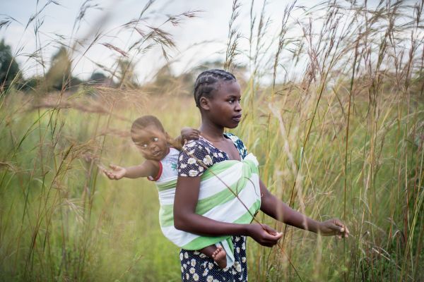 Portrait of Glenda Chidyausiku (20) and her young son Malcolm (1), named after Malcolm X, on their small farm outside Domboshawa, Zimbabwe, on March 13, 2018.