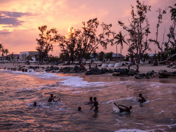 Dusk falls over a group swimming along the ocean's shore in Beira, Mozambique, on November 15, 2019.