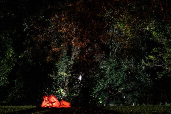 Nearly a week into a self-quarantine, Zelalem Mulat Teklewold follows news of the ongoing COVID-19 pandemic on his phone beneath a tree just outside his home in Nairobi, Kenya, on March 20, 2020.