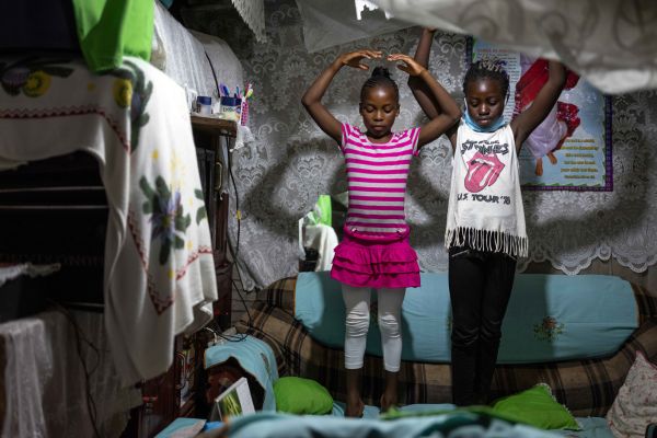 Lydia Akoth and her best friend Valentine Ayuma, both 10, practice ballet through an online class on the sofa of Lydia’s home in Kibera, the largest of more than 100 informal settlements in Nairobi, on June 5, 2020.