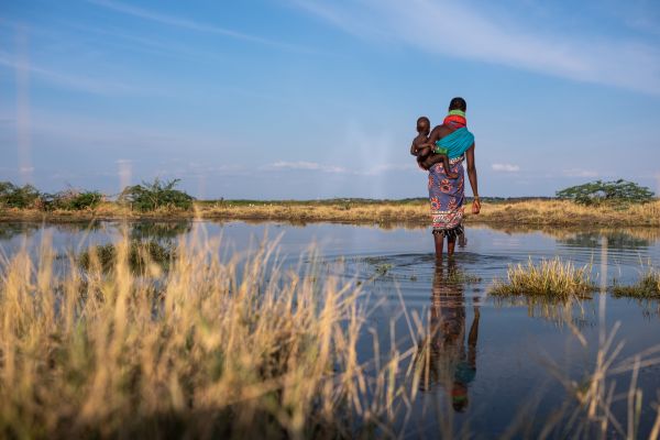 Rebecca Akamasi carries her child Akal Akamasi across a small inlet off Lake Turkana beyond Kalokol town, on August 8, 2020.