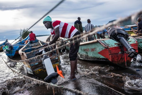 A fishermen secures an Asobo electric engine as he prepares his boat to return to Lake Victoria for a night of fishing from Koguna Beach in Mbita, Kenya, on May 10, 2021.