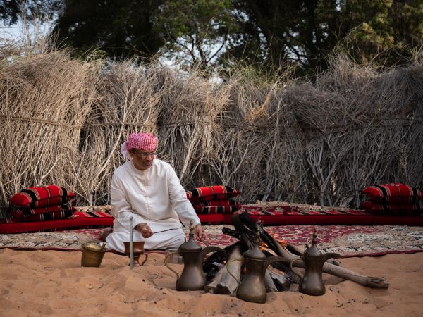 Guide makes a traditional cup of ‘qahwa’, the Arabic word for coffee, at the Heritage Village in Abu Dhabi, the capital of the United Arab Emirates, on July 19, 2022.