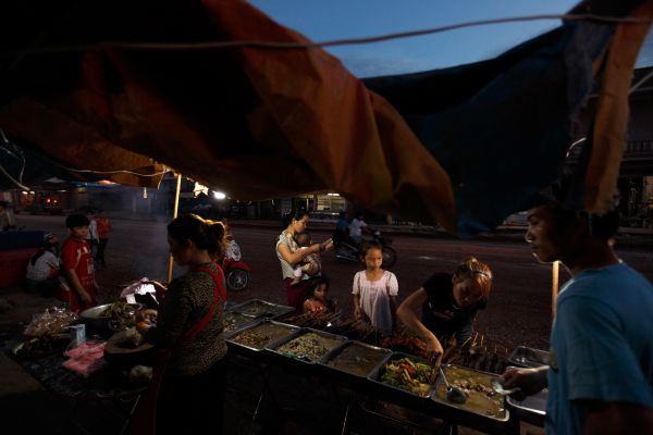 Local villagers buy pre-cooked food from a market stall in Lak Sao in eastern Laos.