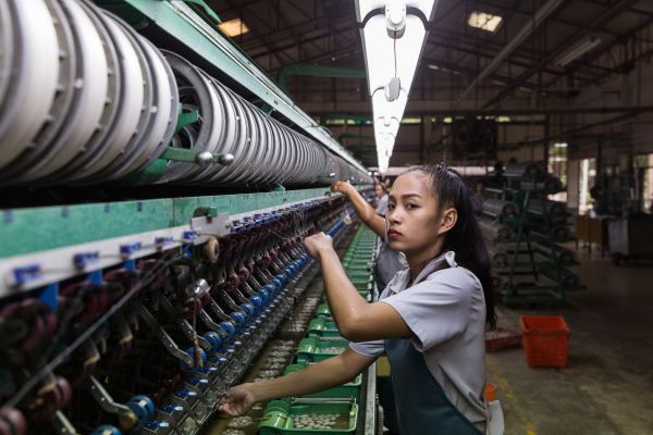 Employees of the Jim Thompson Silk Company work inside the mechanised reeling room at the Jim Thompson silk factory in Nakhon Ratchasima Province.