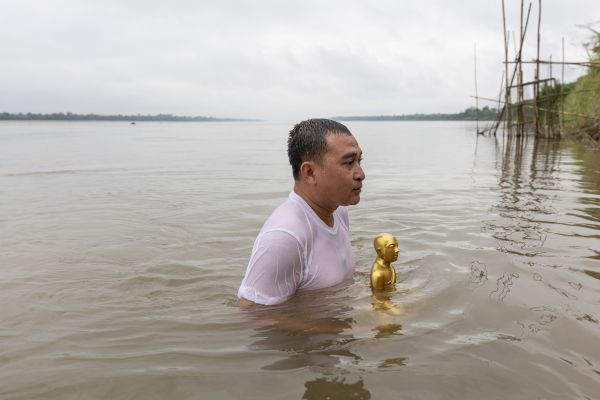 A village head takes part in an annual Buddhist ceremony on the River Mekong that pays respect to the river in Chai Buri district.