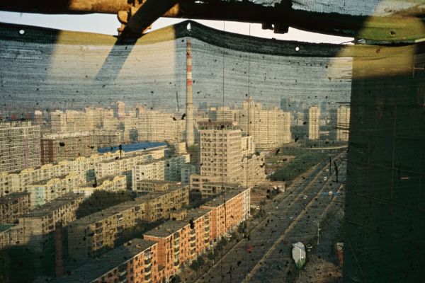 Netting over a hotel construction site frames the view of a neighborhood in the Tiexi Industrial District in Shenyang, China