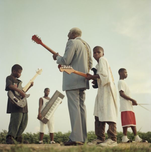 Portrait  of Blues musican Johnnie Billington near a cotton field at Clarksville, Mississippi with young proteges.